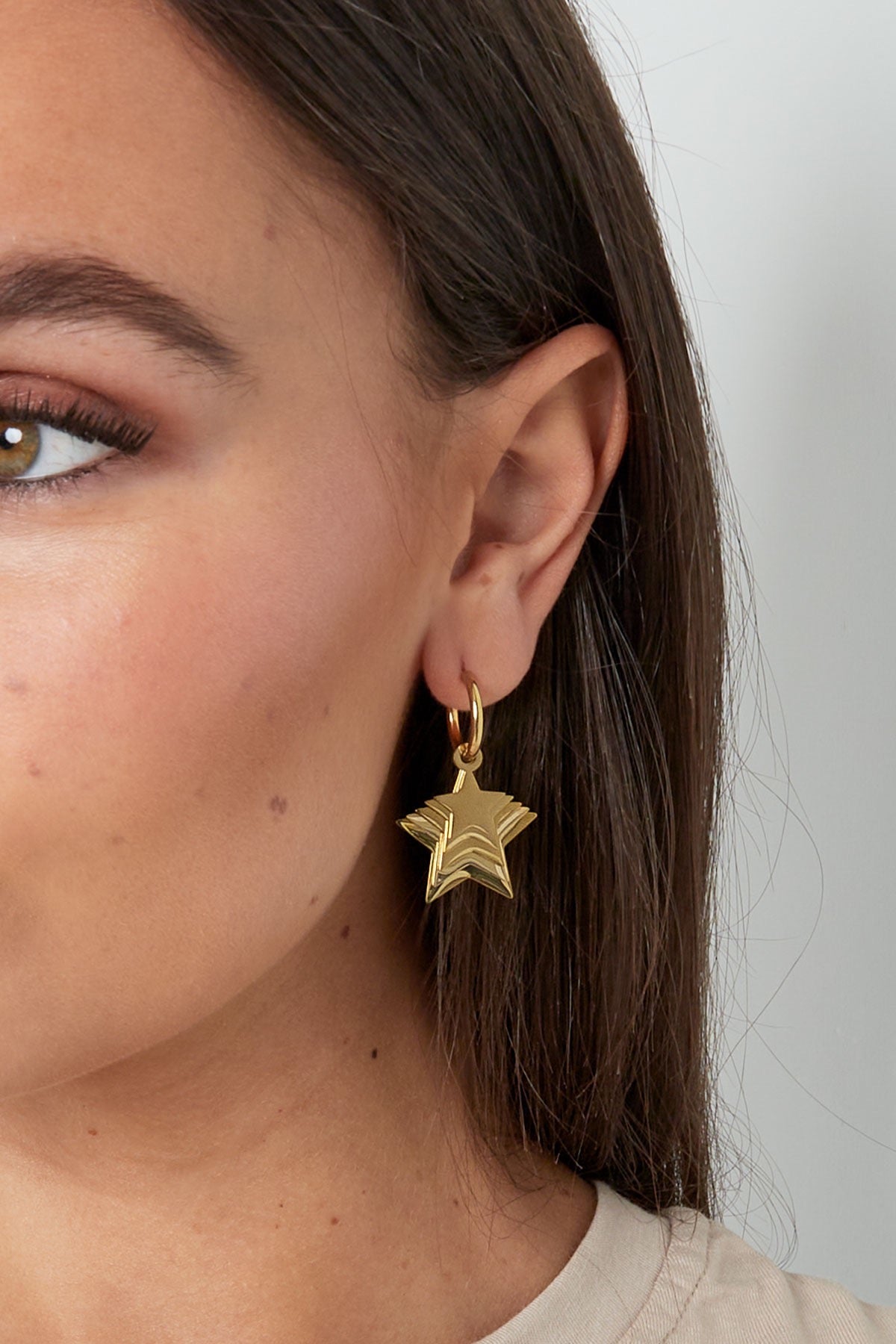 Detailopname van de gouden Oorbellen | Sterren van Louxx the brand, die elegant in het oor valt met een mooi sterontwerp.