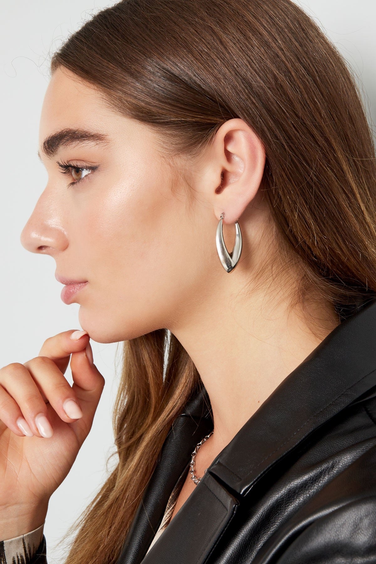 Zijaanzicht van een model met zilveren oorbellen van Louxx the brand, ideaal voor dagelijkse en feestelijke outfits. Oorbellen | Aesthetic.