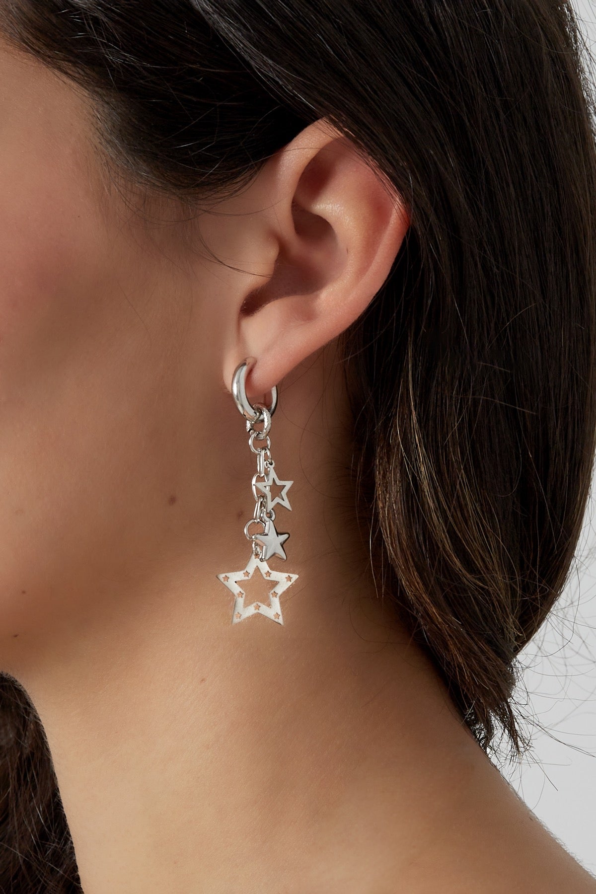 Close-up afbeelding van de Oorbellen | Gedraaid van Louxx the brand. De zilveren oorbellen met sterrenhangers zijn elegant en passen perfect bij elke outfit.