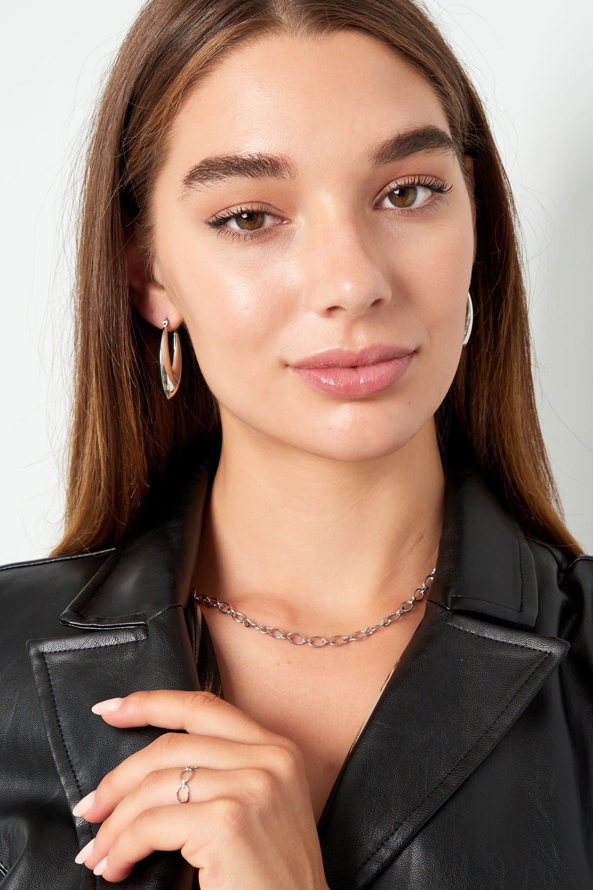 Model die de zilveren oorbellen van Louxx the brand draagt, met een casual chique uitstraling. Oorbellen | Aesthetic.