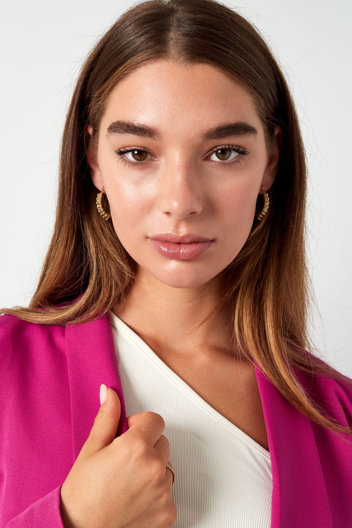 Nabijzicht van een vrouw met gouden bubbel oorbellen van Louxx the brand. Perfecte moderne oorbellen voor dames in een modebewuste outfit.