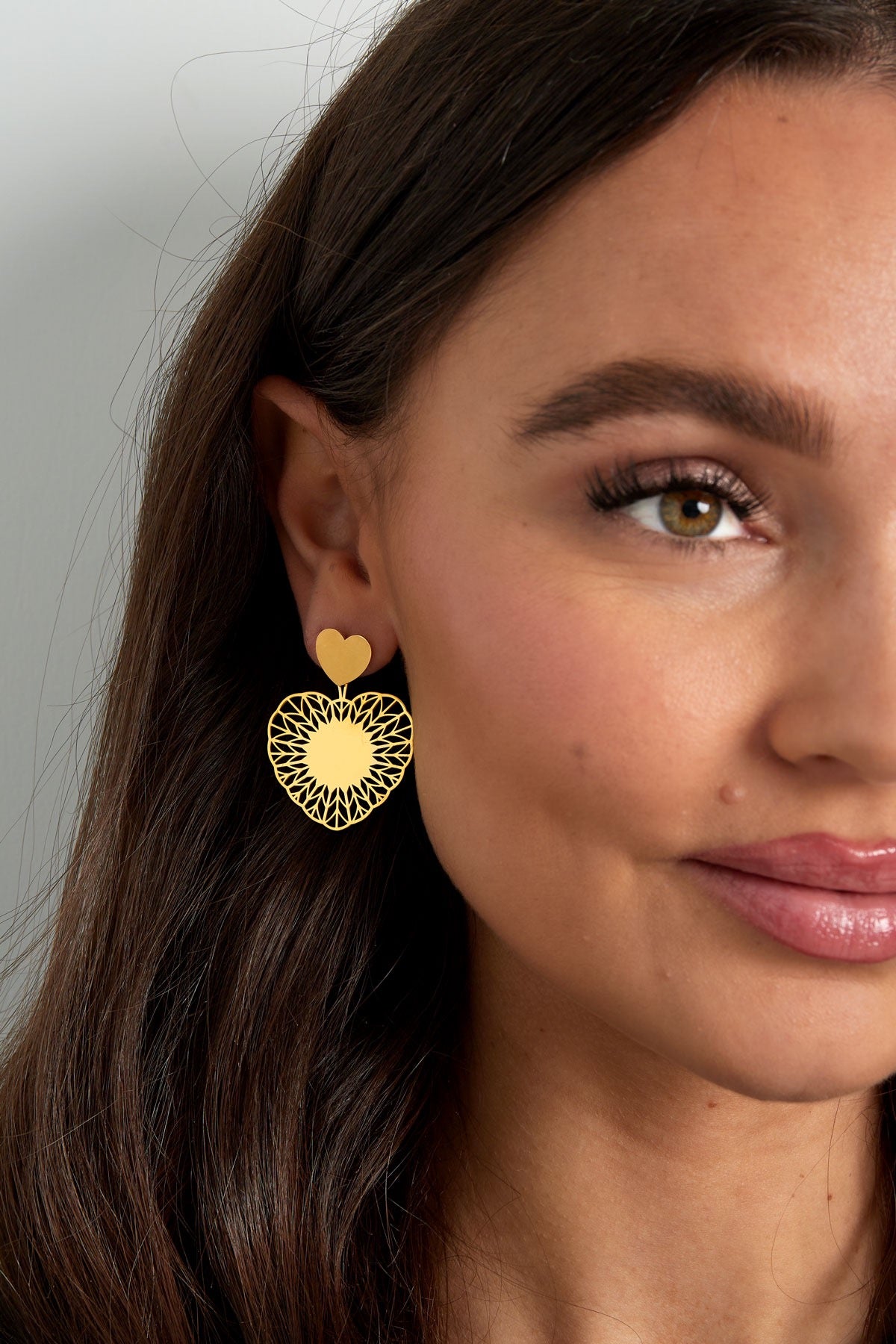 Dichtbij beeld van gouden hart oorbellen van Louxx the brand, een prachtige accessoire voor elke gelegenheid.