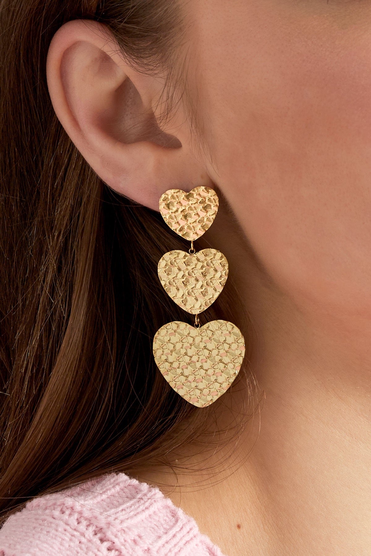 Close-up van de gouden hart oorbellen van Louxx the brand, met een glanzende afwerking en een elegante uitstraling. Deze hart oorbellen goud zijn een trendy accessoire.