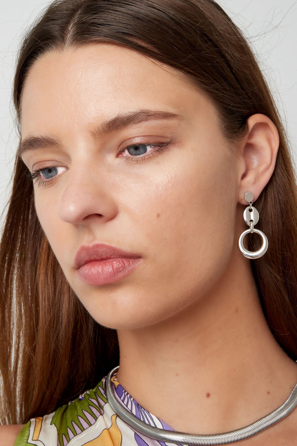 Modieuze Oorbellen | Schakels van Louxx the brand, gedragen door een model. De zilveren oorbellen accentueren een verfijnde look.