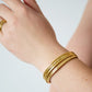 Combinatie van goudkleurige bangles gedragen om de pols