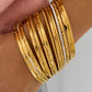 Goudkleurige bangle Ster gecombineerd met andere armbanden om de pols